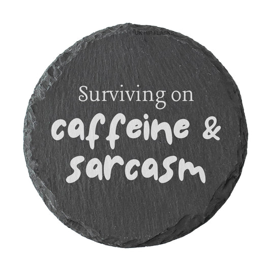 Round coaster with the quote "surviving on caffeine and sarcasm" in white text.