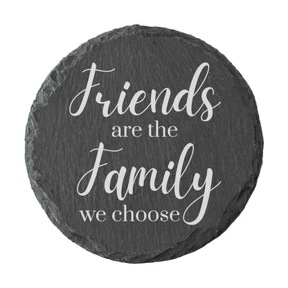 Round slate coaster with the text 'Friends are the family we choose' on a white background