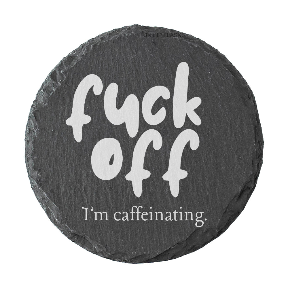Round slate coaster with the text "Fuck off I'm caffeinating" on a white background