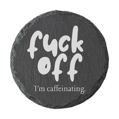 Round slate coaster with the text "Fuck off I'm caffeinating" on a white background