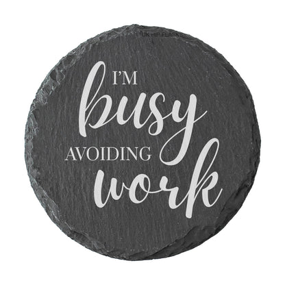 Round slate coaster with 'I'm busy avoiding work' text on a white background