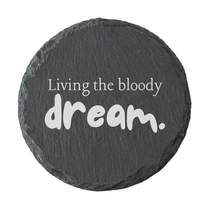 Round slate coaster with 'Living the bloody dream.' text on a white background