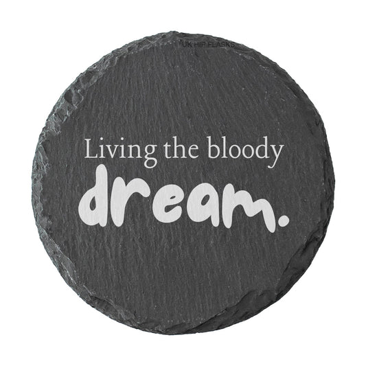 Round slate coaster with 'Living the bloody dream.' text on a white background