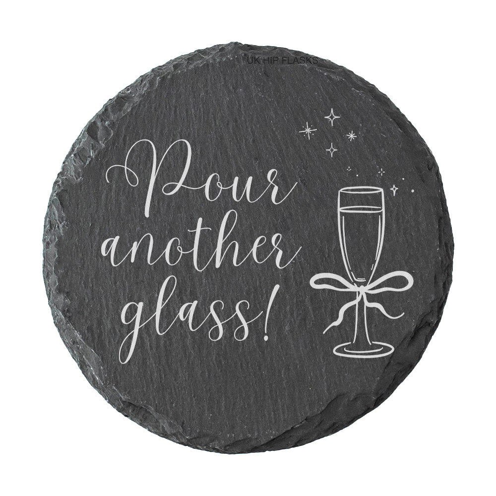 Round slate coaster with 'Pour another glass!' text and champagne glass illustration on a white background