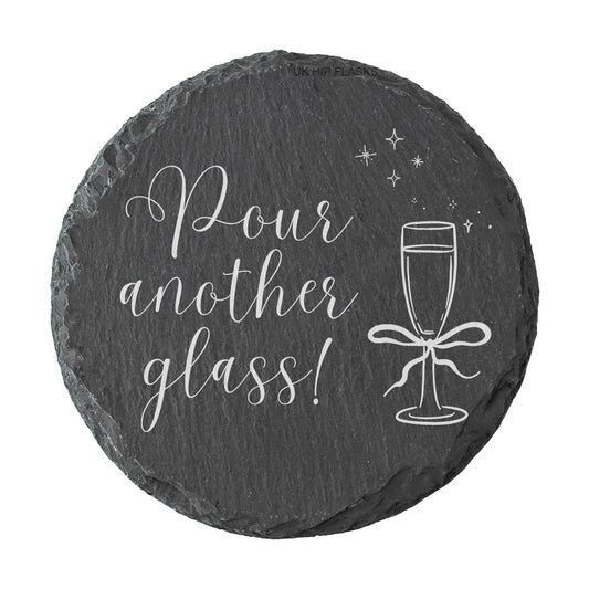 Round slate coaster with 'Pour another glass!' text and champagne glass illustration on a white background