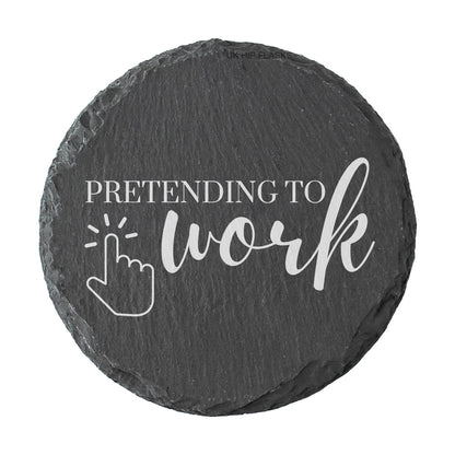 Round slate coaster with 'Pretending to work' text and cursor icon on a white background