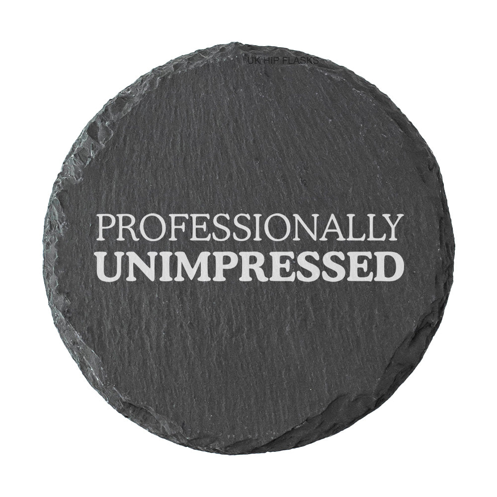Round slate coaster with 'PROFESSIONALLY UNIMPRESSED' text on a white background