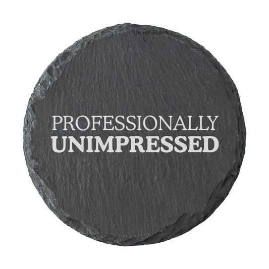 Round slate coaster with 'PROFESSIONALLY UNIMPRESSED' text on a white background