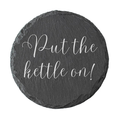 Round slate coaster with 'Put the kettle on!' text on a white background