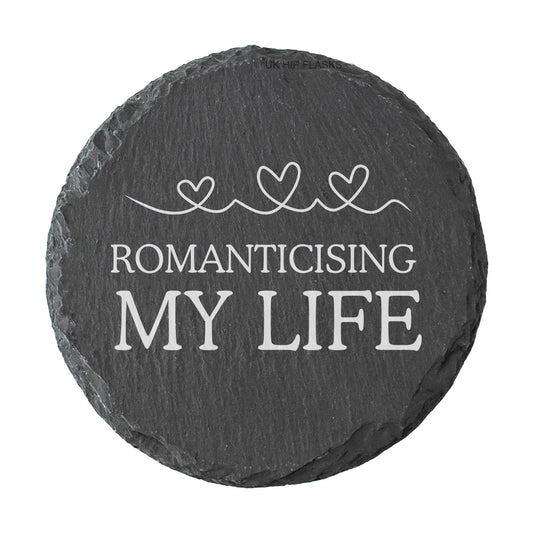 Round slate coaster with 'Romanticising My Life' text and heart designs on a white background