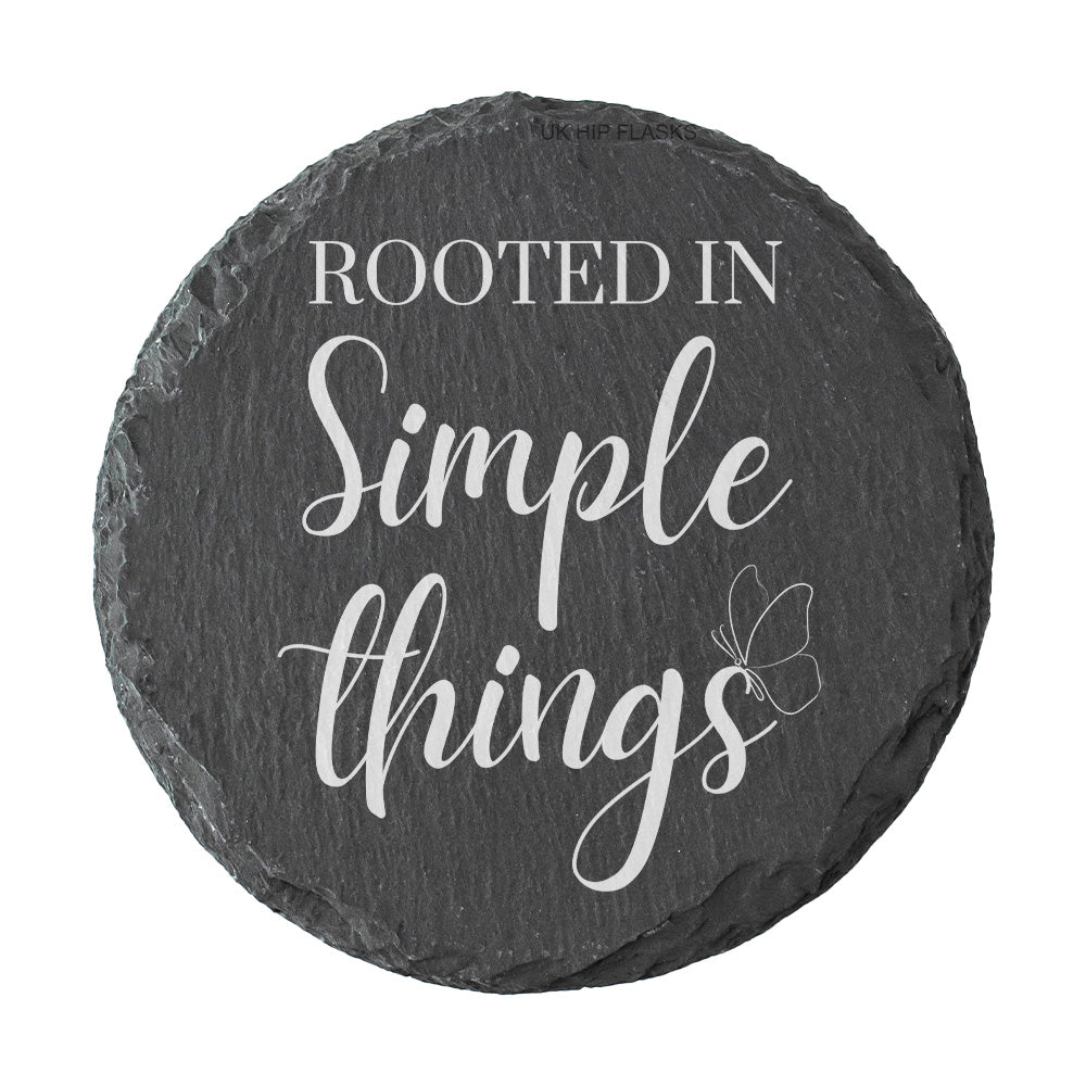 Round slate coaster with 'Rooted in Simple Things' text on a white background