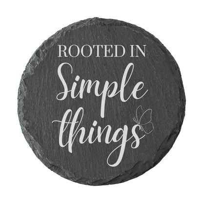 Round slate coaster with 'Rooted in Simple Things' text on a white background