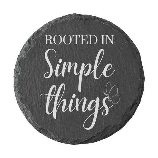 Round slate coaster with 'Rooted in Simple Things' text on a white background