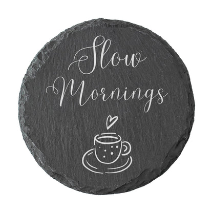 Round slate coaster with 'Slow Mornings' text and a cup illustration on a white background