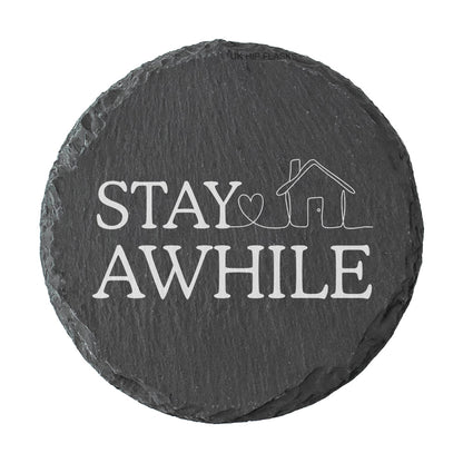 Round slate coaster with 'Stay Awhile' text and house icon on a white background