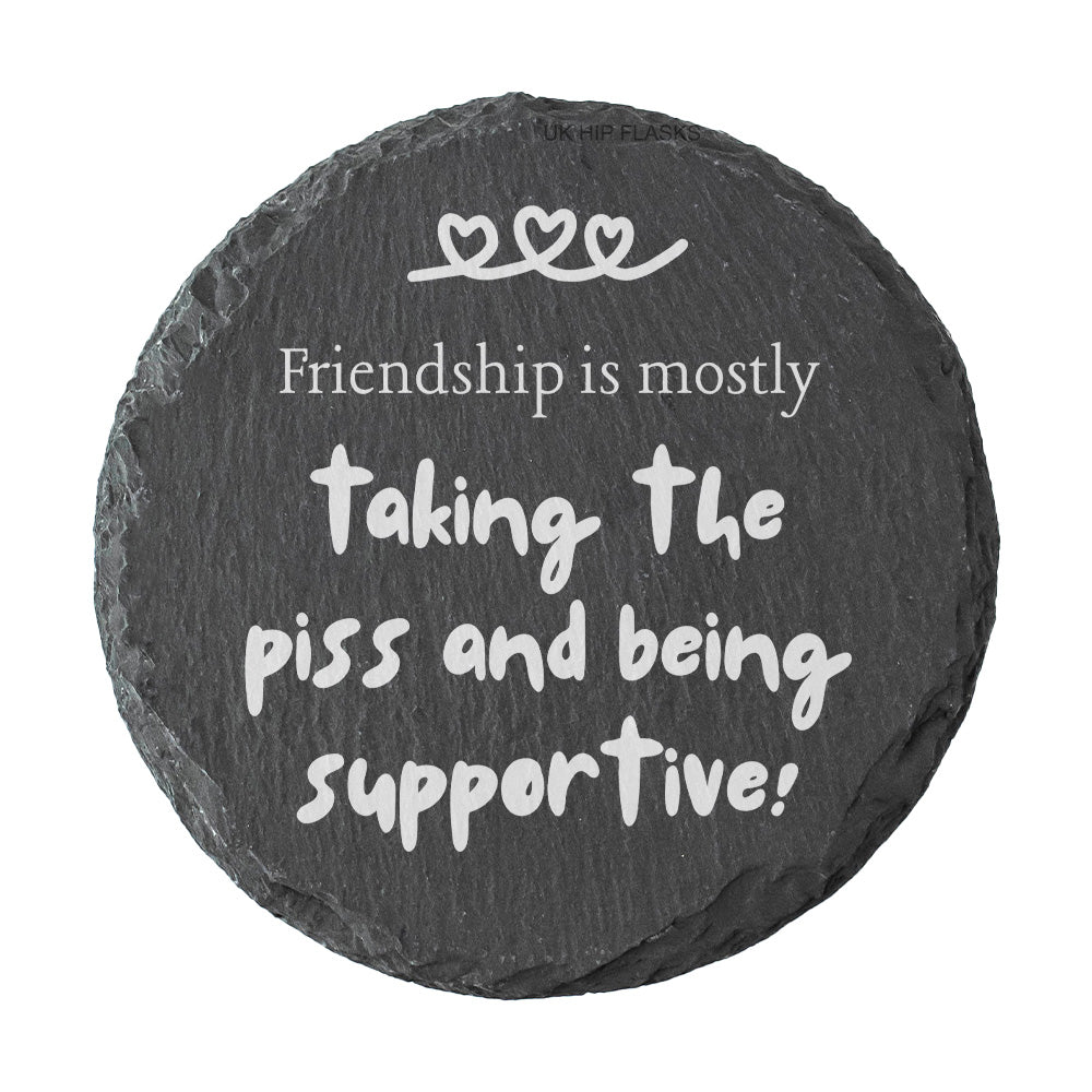 Round slate coaster with the quote "Friendship is mostly taking the piss and being supportive!" on a white background