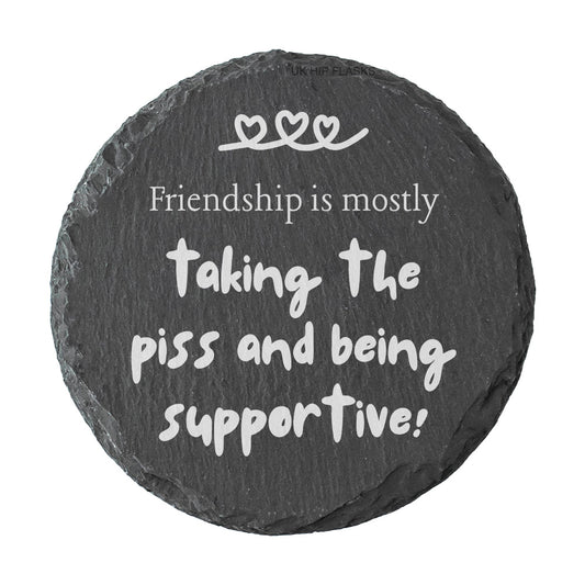 Round slate coaster with the quote "Friendship is mostly taking the piss and being supportive!" on a white background