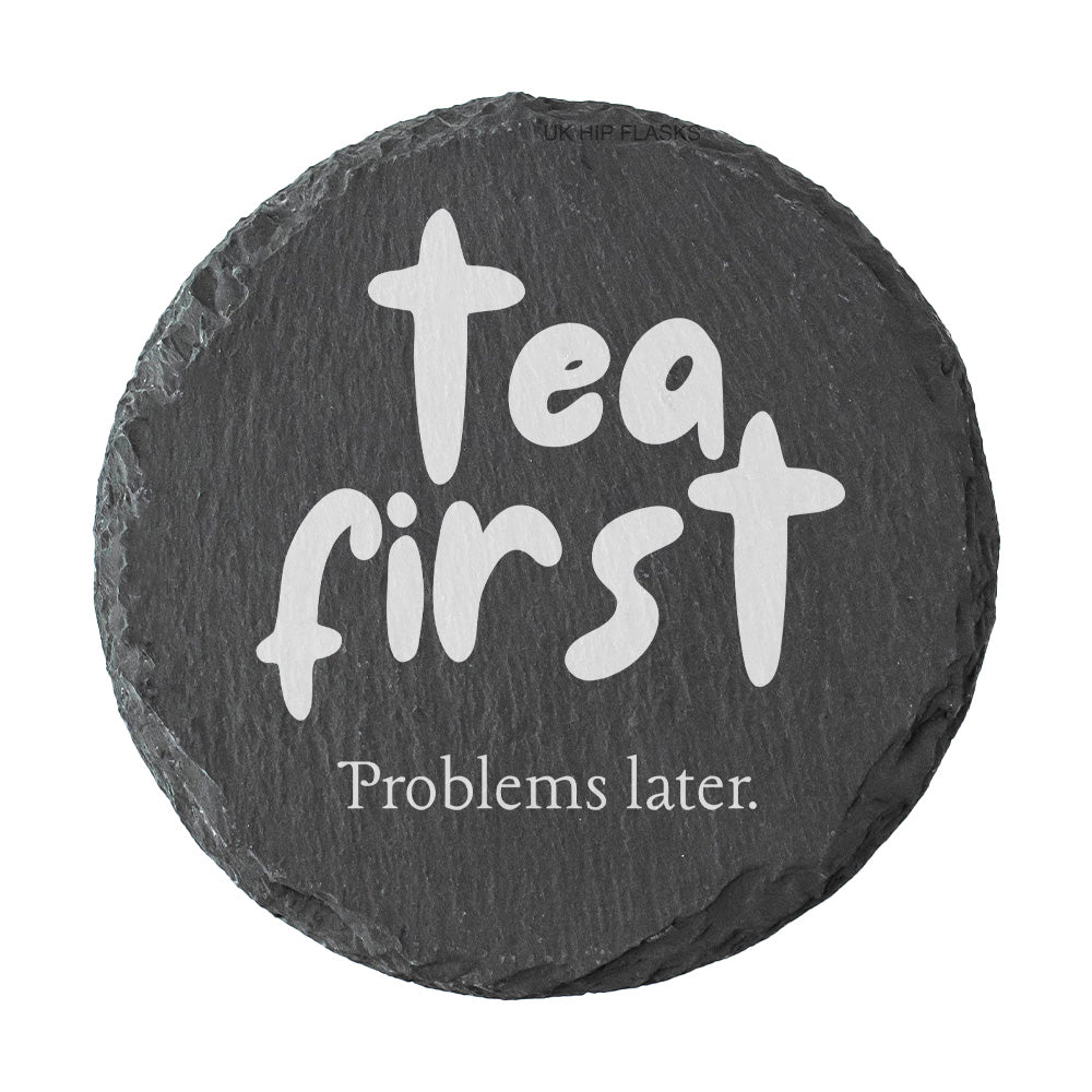 Round slate coaster with the quote "Tea first problems later" in white text.