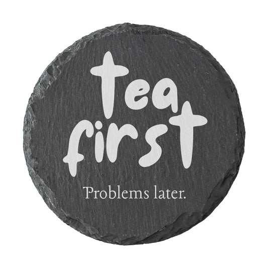 Round slate coaster with the quote "Tea first problems later" in white text.