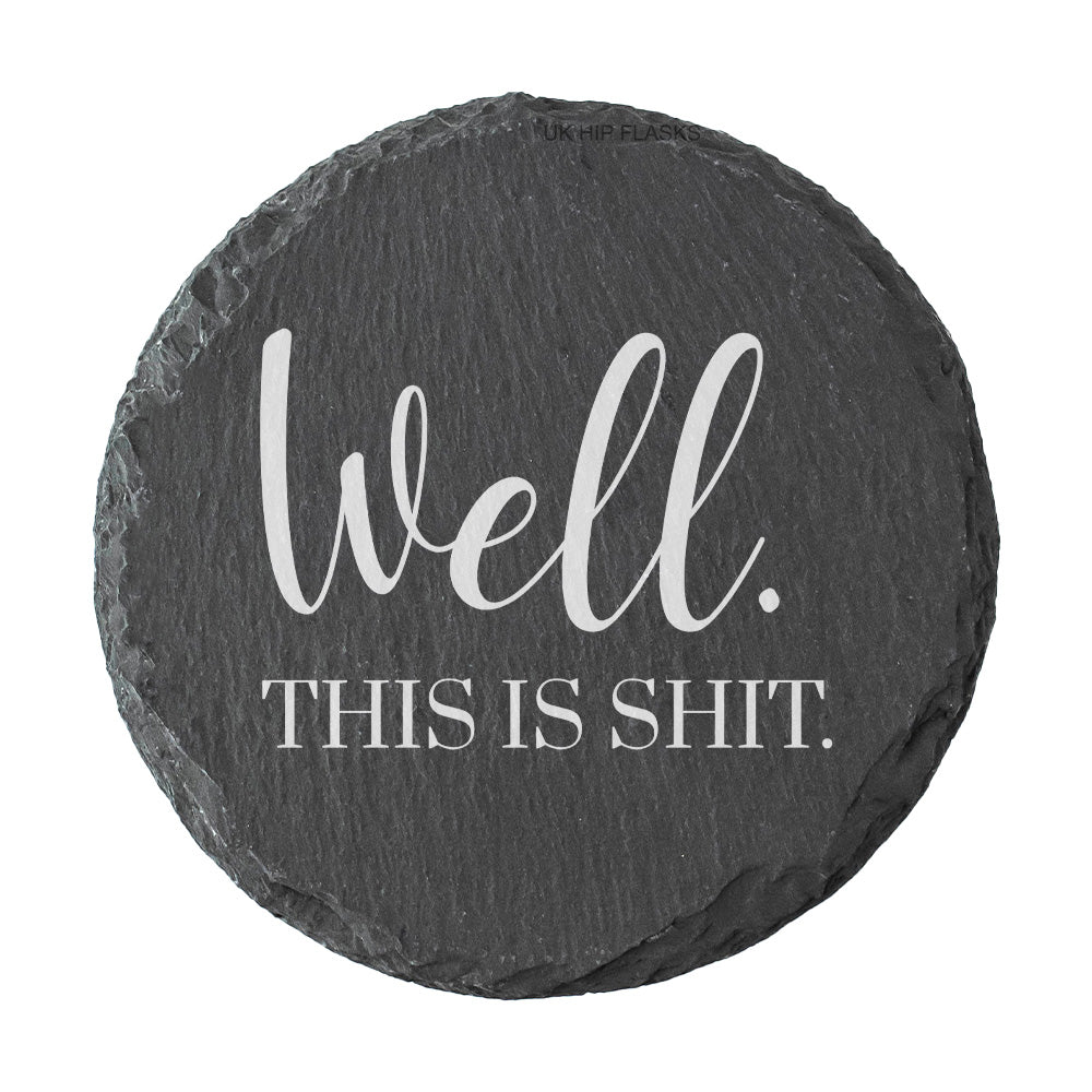Round slate coaster with text 'Well. This is shit.' on a white background