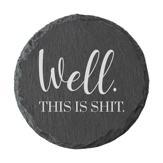 Round slate coaster with text 'Well. This is shit.' on a white background