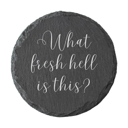 Round slate coaster with "what fresh hell is this?" text on a white background
