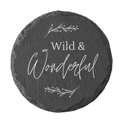 Round slate coaster with 'Wild & Wonderful' text and leaf designs on a white background