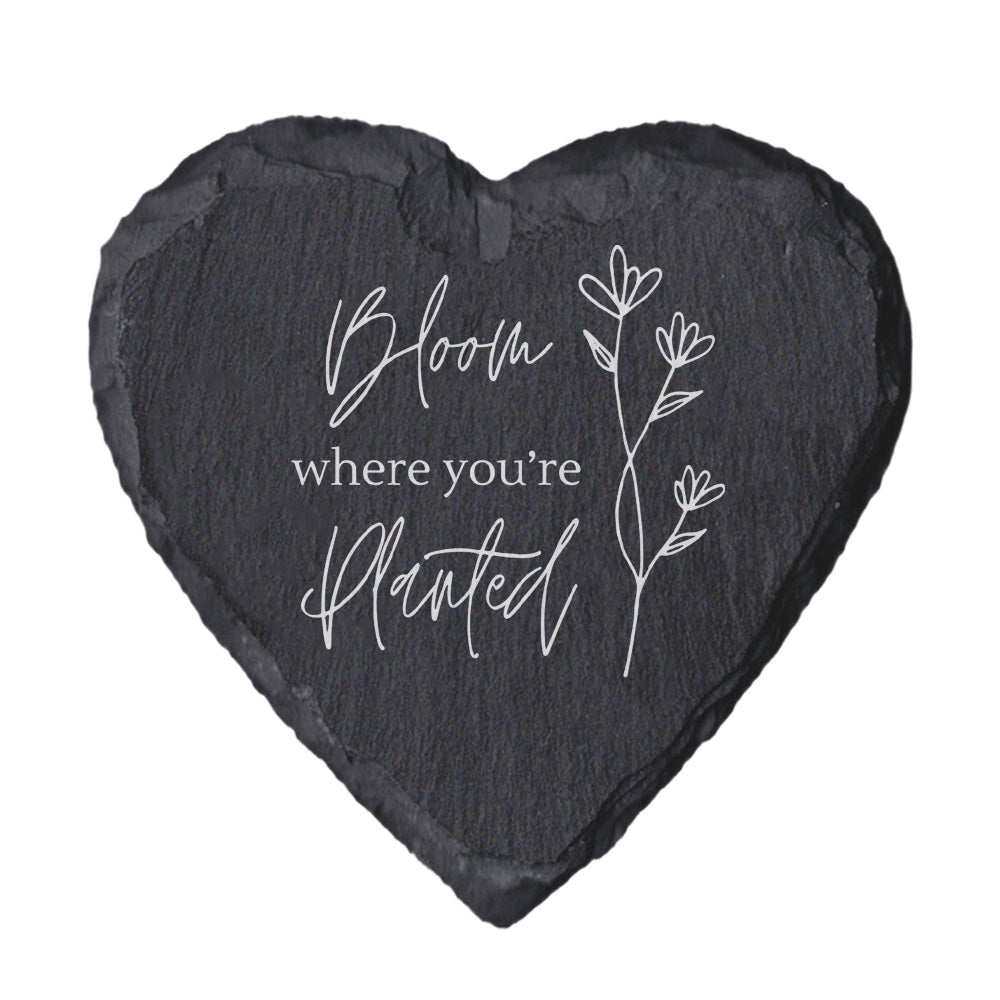 Heart-shaped slate with 'Bloom where you're planted' text and floral design on a white background