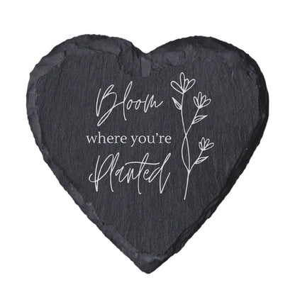 Heart-shaped slate with 'Bloom where you're planted' text and floral design on a white background