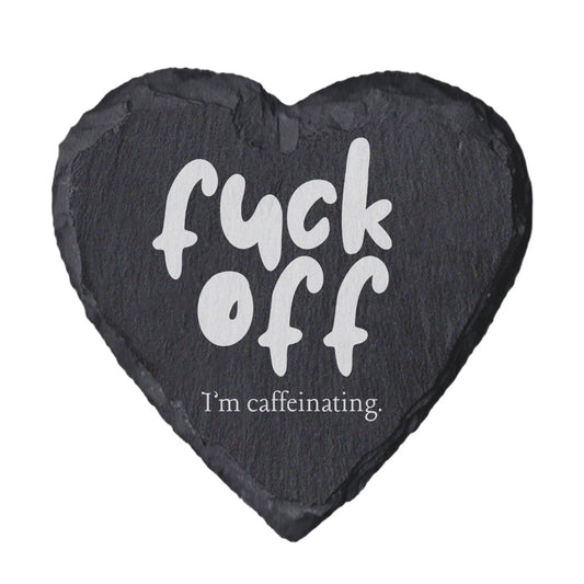 Heart-shaped slate coaster with text 'f*ck off I'm caffeinating' on a white background