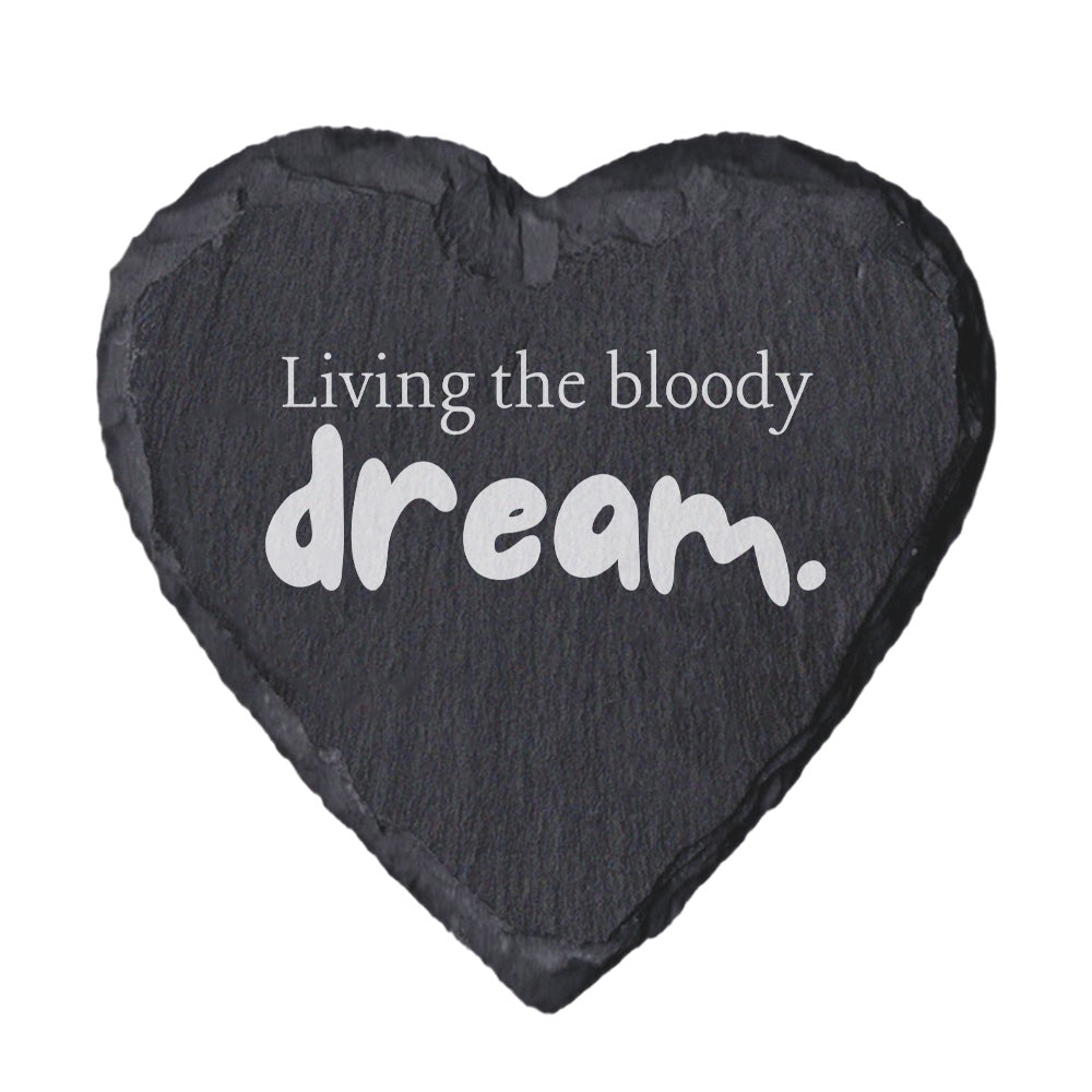 Heart-shaped slate coaster with 'Living the bloody dream' text on a white background