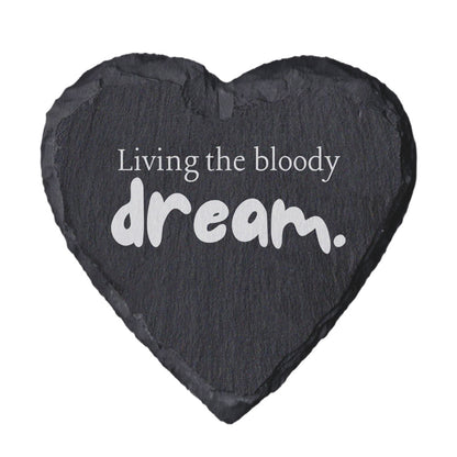 Heart-shaped slate coaster with 'Living the bloody dream' text on a white background