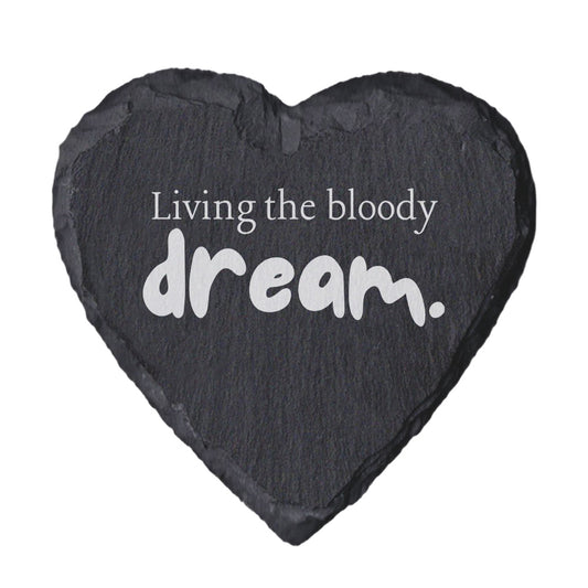 Heart-shaped slate coaster with 'Living the bloody dream' text on a white background