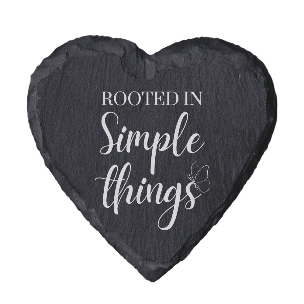 Heart-shaped slate coaster with 'Rooted in Simple Things' text on a white background