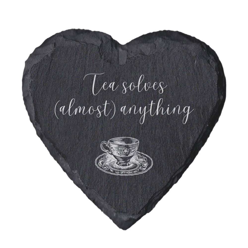 Heart-shaped slate coaster with tea cup illustration and 'Tea solves (almost) anything' text on a white background