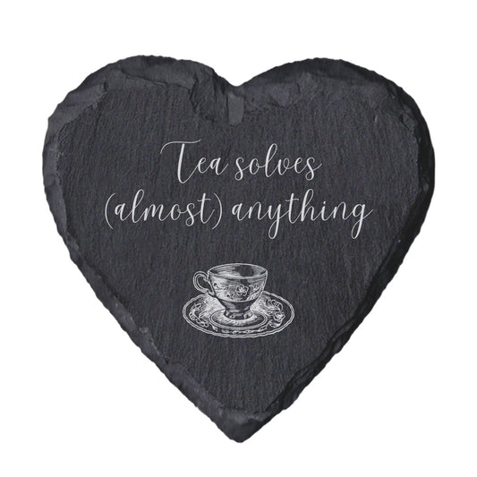 Heart-shaped slate coaster with tea cup illustration and 'Tea solves (almost) anything' text on a white background
