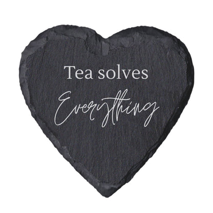 Heart-shaped slate coaster with 'Tea solves Everything' text on a white background