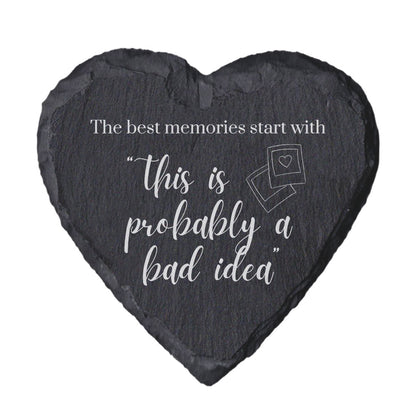 Heart-shaped slate coaster with quote "The best memori9es start with this is probably a bad idea" on a white background