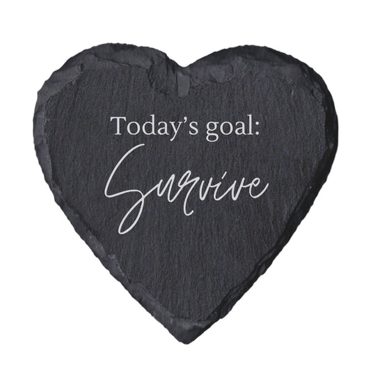 Heart-shaped slate coaster with 'Today's goal: Survive' text on a white background