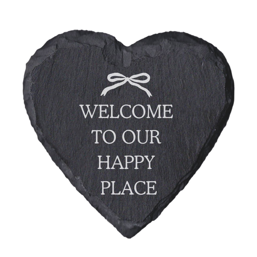 Heart-shaped slate coaster with "welcome to our happy place" quote in white text.