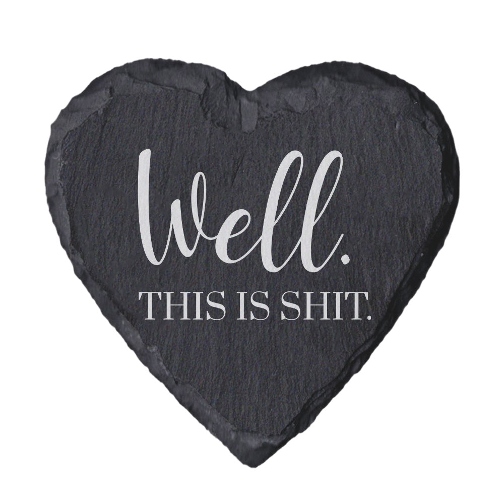 Heart-shaped slate coaster with text 'Well. This is shit.' on a white background