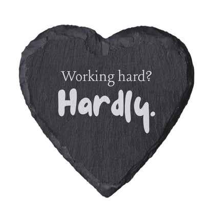 Heart-shaped slate coaster with 'Working hard? Hardly.' text on a white background