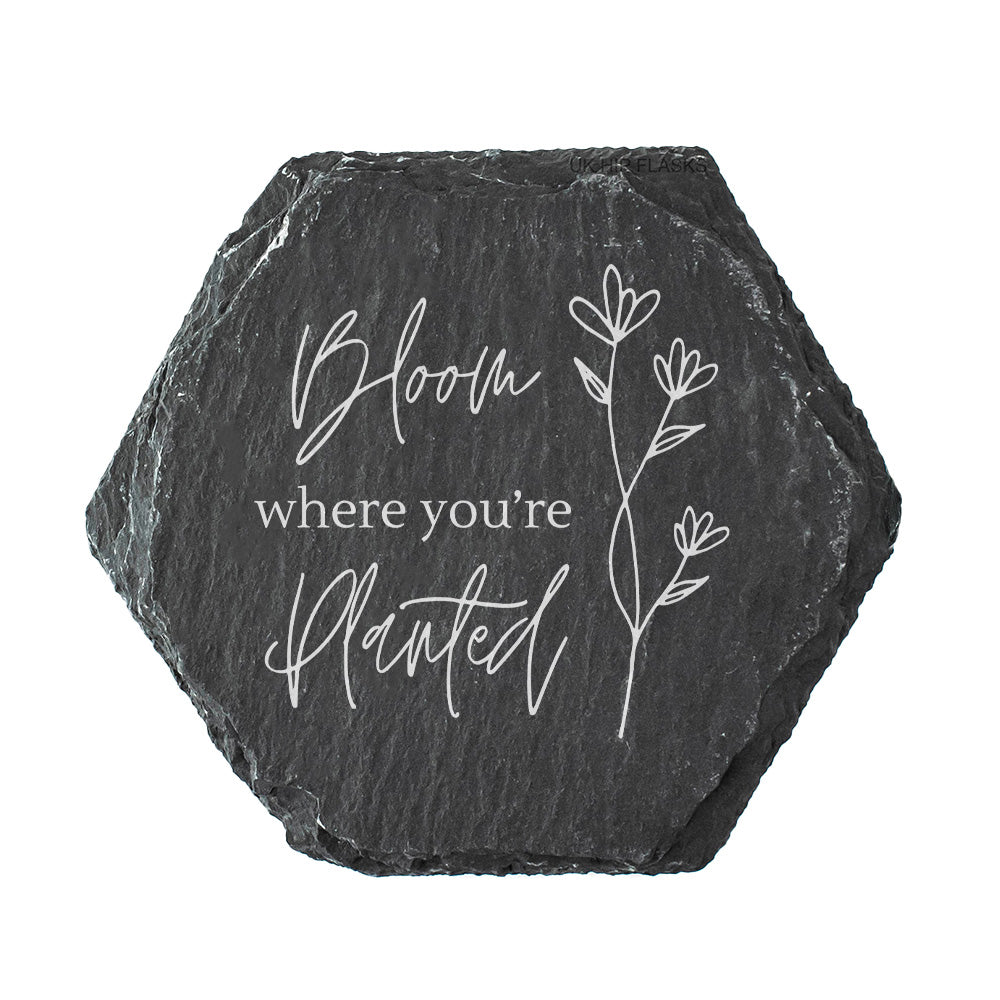 Hexagonal slate coaster with 'Bloom where you're planted' text and floral design on a white background