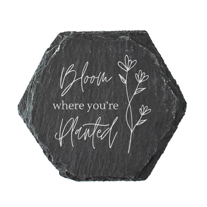 Hexagonal slate coaster with 'Bloom where you're planted' text and floral design on a white background