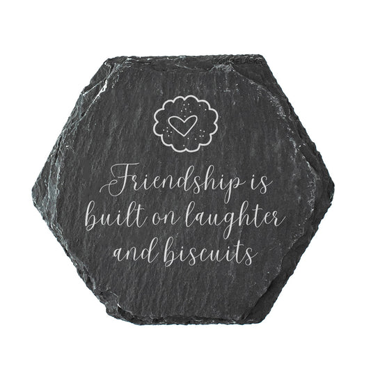 Hexagonal slate coaster with 'Friendship is built on laughter and biscuits' text and a heart design.