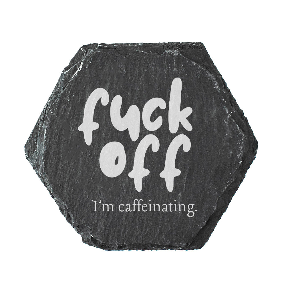 Hexagonal black slate coaster with white text 'fuck off I'm caffeinating' on a white background