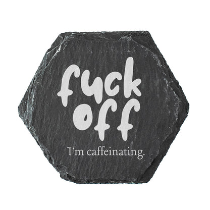 Hexagonal black slate coaster with white text 'fuck off I'm caffeinating' on a white background