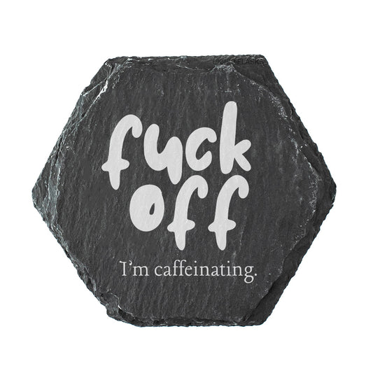 Hexagonal black slate coaster with white text 'fuck off I'm caffeinating' on a white background