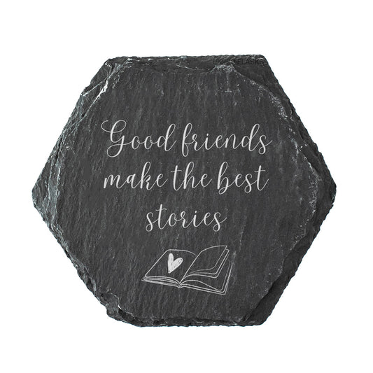 A hexagon slate coaster with the quote "good friends make the best stories" in white text.