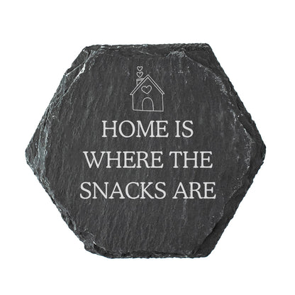 Hexagonal black slate coaster with 'Home is where the snacks are' text on a white background